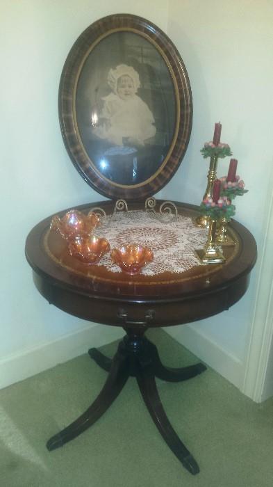 Tiger oak oval convex frame, Round foyer table, carnival glass bowls, brass candlesticks, doileys. 