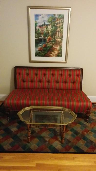 Framed art is just OK, but the antique settee is quite nice, freshly reupholstered, resting on a hand woven, 100% wool rug, anchored by a La Barge-ish brass/glass coffee table on faux bamboo stand. 