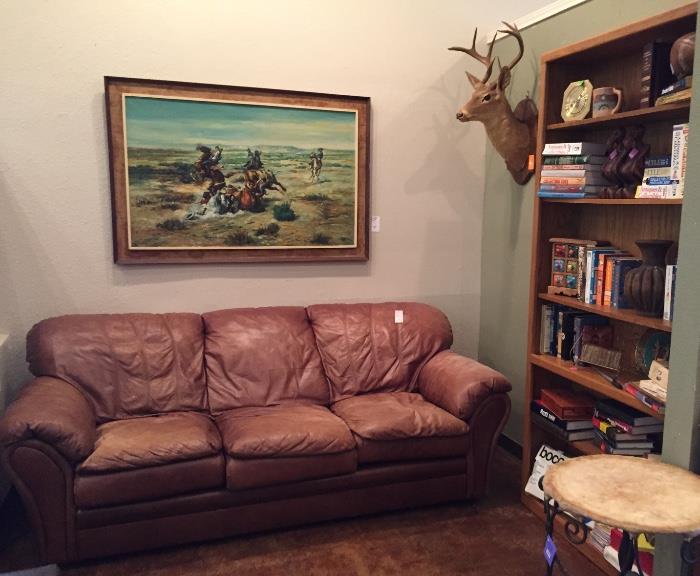 Brown leather sofa, books, art, deer head