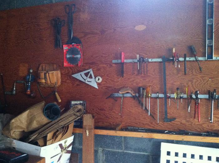 An assortment of tools. There are also several useful long-handled garden implements.
