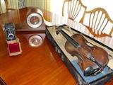 Vintage student violin on lovely dining room table with six chairs.