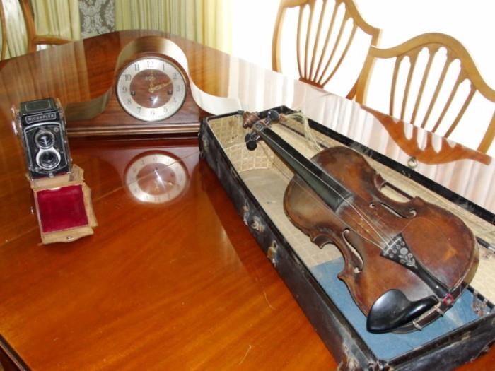 Vintage student violin on lovely dining room table with six chairs.