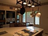 cooking pans , glass top table with chairs, bar stools