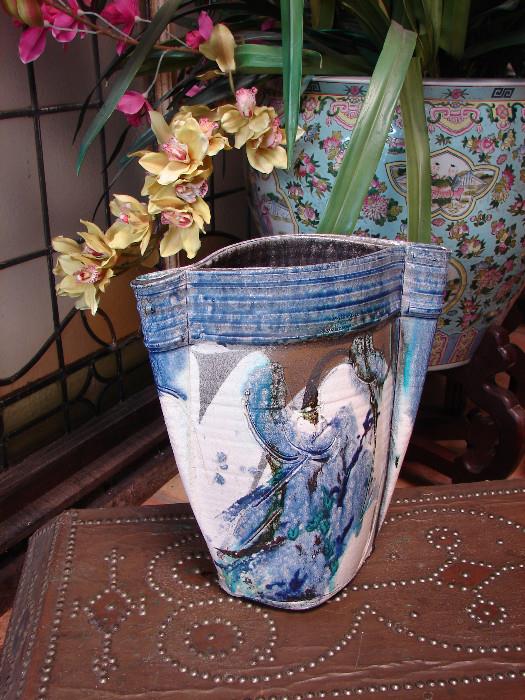 Hand made pottery vase. Unsigned. 14" - one of several over sized Chinese fish bowls shown in background. One of two metal embossed trunks shown in foreground.
