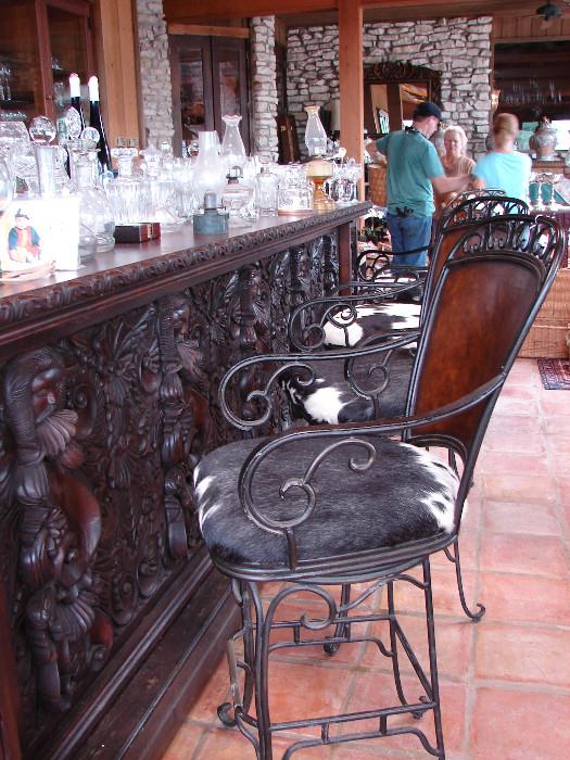 Bar stools with cowhide seat covers. Large carved bar. Bar will not be available until later in the autumn but may be purchased and placed on hold.