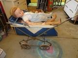 Old baby buggy with a few dolls