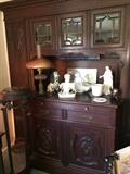 Intricately carved antique china cabinet; marble top plant stand