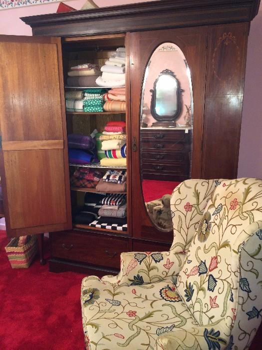 Inlaid walnut wardrobe with oval beveled mirrors; wing back chair