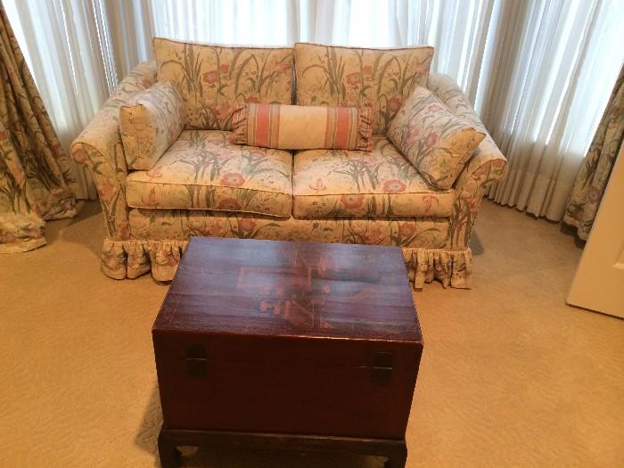 Quaint upholstered bedroom love seat and red Asian chest