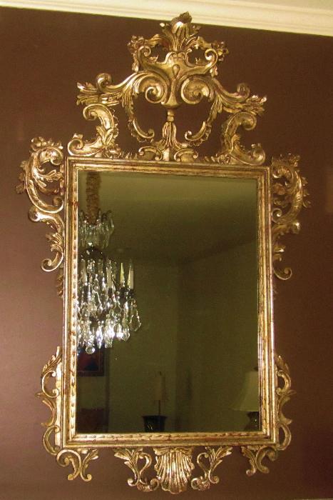 French Rococo-style mirror. Magnificent piece! Approximately 40" w; 60" h. It is suggested this piece be professionally moved. The top structure is very vulnerable to fracture on frames of this type.
