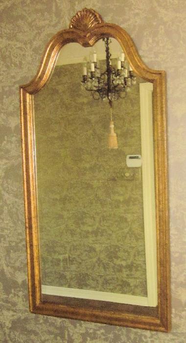 Gold framed French pediment mirror with shell motif. 23" w; 46" h.