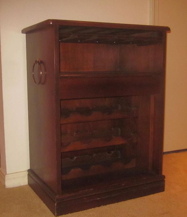 Wine cabinet. Has three rack levels, and rack for wine glasses inside, at the top. Top work surface is cork.