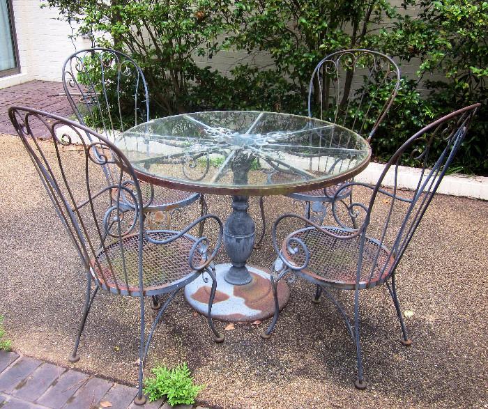 Round, iron table with glass top, and four iron, high-backed arm chairs; Sturdy, but needs re-painting.