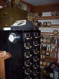 Nice multi-drawer metal cabinet, bunches of clocks.