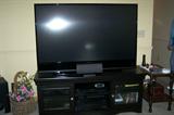 Large TV (5 years old) on low stand, surround sound system and more.