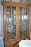 Contemporary pine china cupboard with matching kitchen table (glass top) and 4 chairs. Cabinet filled with glassware and linens.