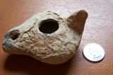 First to third century antiquity: Early Roman clay lamp--shown with quarter for size comparison.