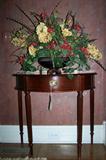 Small console table with decorative floral arrangement.