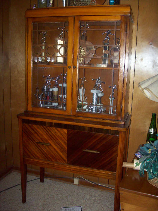 Vintage curio cabinet or china cabinet. This one is loaded with 1960s bowling trophies. We expect to find some more bowling stuff from that era.