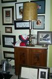 Antique furniture surrounded by floor to ceiling framed art, autographs and memorabilia.