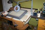 Drafting table with light box and lots of art supplies.