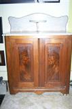 Antique washstand with marble top and curved back splash.