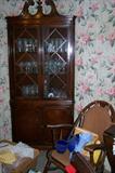 Antique corner cabinet filled with collectible glassware.