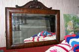 Antique beveled mirror in decorative oak frame.