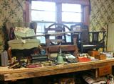 Work room full of upholstery projects, tools and supplies.