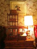 Furniture is stacked up in the front room--cedar chest in front of bed frame with shelf on top and framed print hanging on the wall.