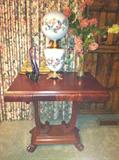 Antique mahogany table with claw feet and center drawer.