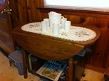 Antique round drop-leaf table, shown with milk glass pitcher and glasses.