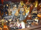 Shelf full of bells in other metals, includes several cow bells.