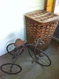Antique tricycle and tall basket with lid.