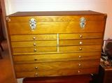 Wooden cabinet with multiple drawers and lift top.