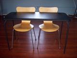 Folding table and two laminated wood contour chairs.