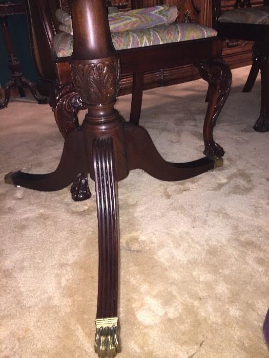 Legs and Brass Claw feet of the Mahogany Table.  Ornate Cabriole Chair legs with claw feet can be seen in the background.  