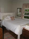 Queen bed with white distressed head and footboard.