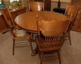 MODERN ROUND OAK TABLE WITH CLAW FEET AND PRESSED BACK CHAIRS