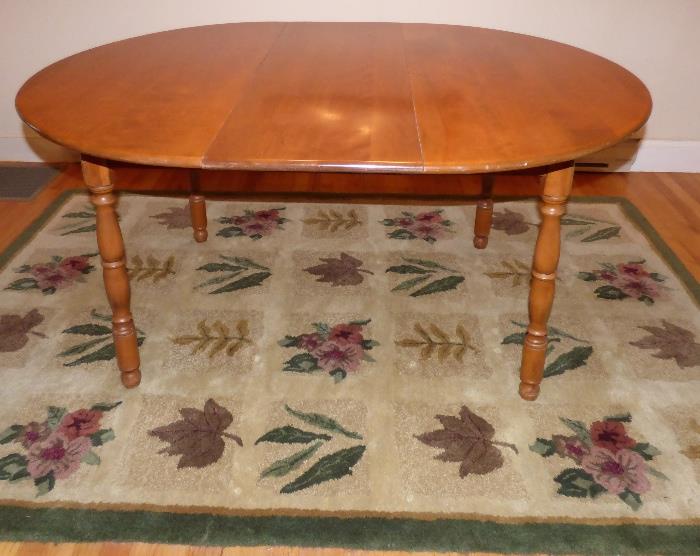 Hand woven area rug with Rockport Maple Table