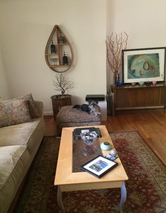 Living room includes a neutral colored down filled sofa for 3, 4 custom pillows to match the chair and ottoman, an Egyptian carpet, 1 coffee table with 2 matching end tables,