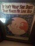 It Isn't What She Does That Makes Me Love Her.  Framed vintage song book.