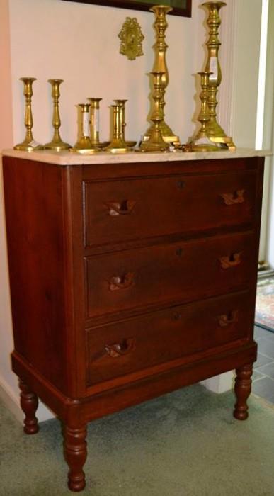 Marble top tall Victorian walnut chest shown with brass candlesticks
