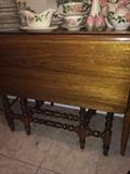 Antique drop leaf table; variety of Desert Rose pottery