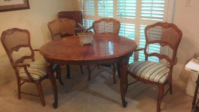 This dining room table has 2 large leaves and table pads. Two arm chairs and 2 regular.