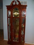 Ridgeway grandfather clock with glass shelves on either side for displaying items.