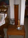 Lamp or end table with decorative items. Behind it is one of two pedestals for sale that were made from organ pipes