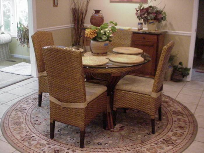 Four side chairs, cushions, and glass top rattan table on pedestal base