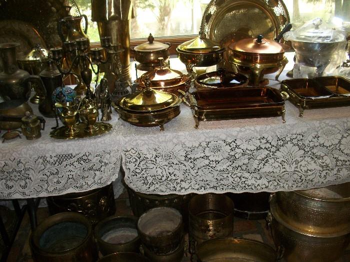 tables filled with brass, copper, and silver plate serving pieces