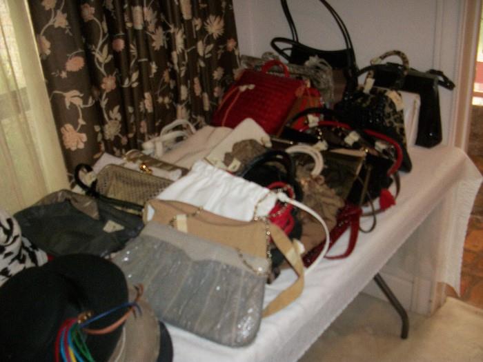 table filled with handbags including two Chanels
